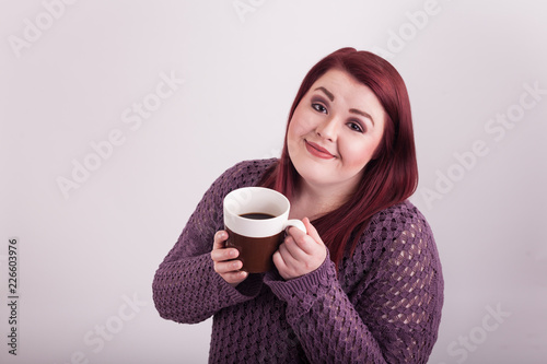 woman with full cup of coffee smiling happy