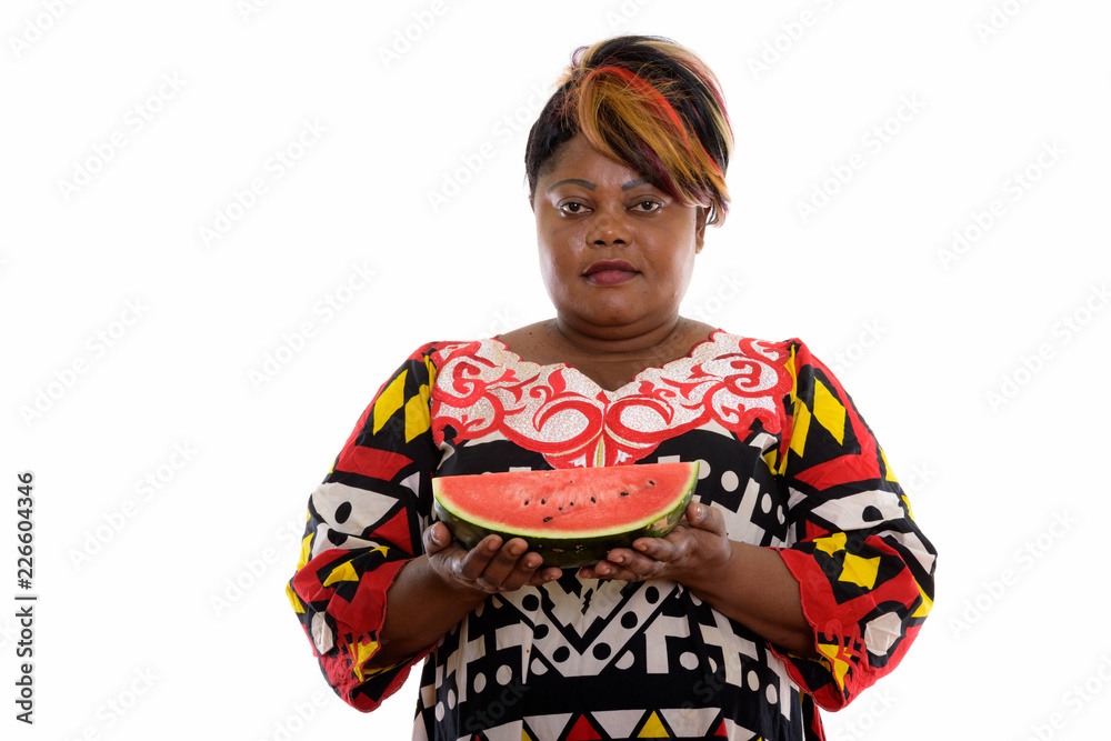 Studio shot of fat black African woman holding slice of watermel Studio shot of fat black African woman holding slice of watermel