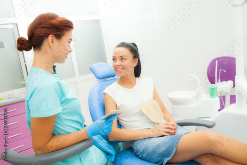 female dentist communicates with a female patient in the treatment room