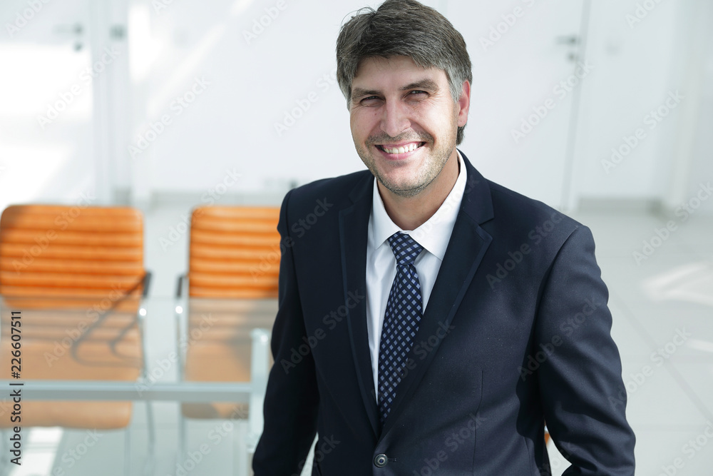 successful businessman standing by the desk. successful businessman standing by the desk.