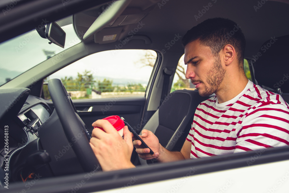 Guy in a car looking at his phone Guy in a car looking at his phone