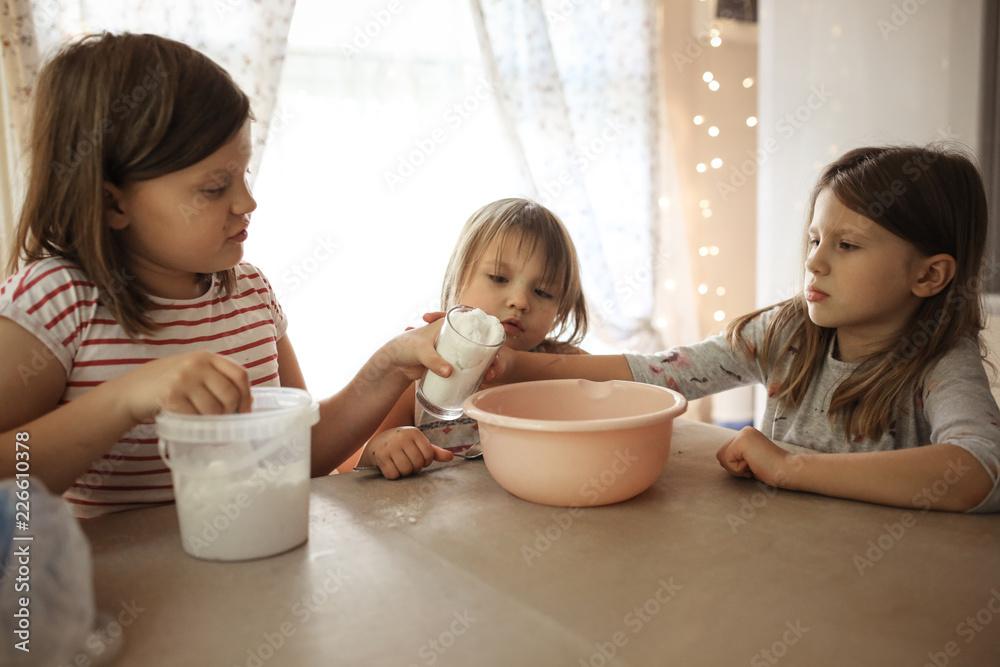Three girls sisters fall flour for dough, siblings Three girls sisters fall flour for dough, siblings