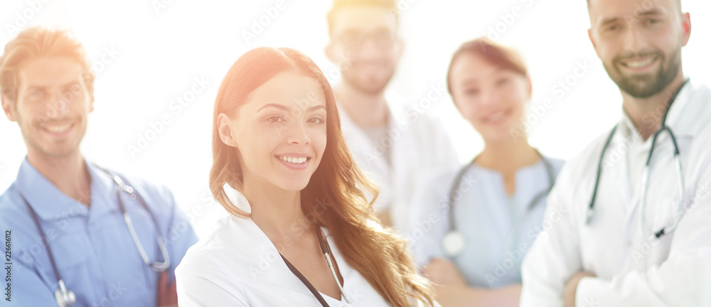 Attractive female doctor with medical stethoscope in front of medical group Attractive female doctor with medical stethoscope in front of medical group