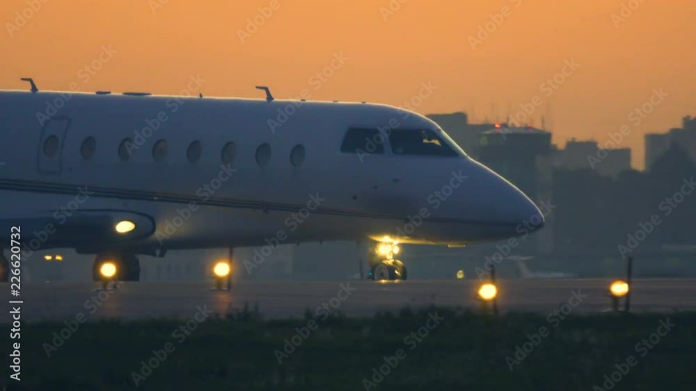 Business jet is taxiing on the taxiway after landing at sunset Business jet is taxiing on the taxiway after landing at sunset