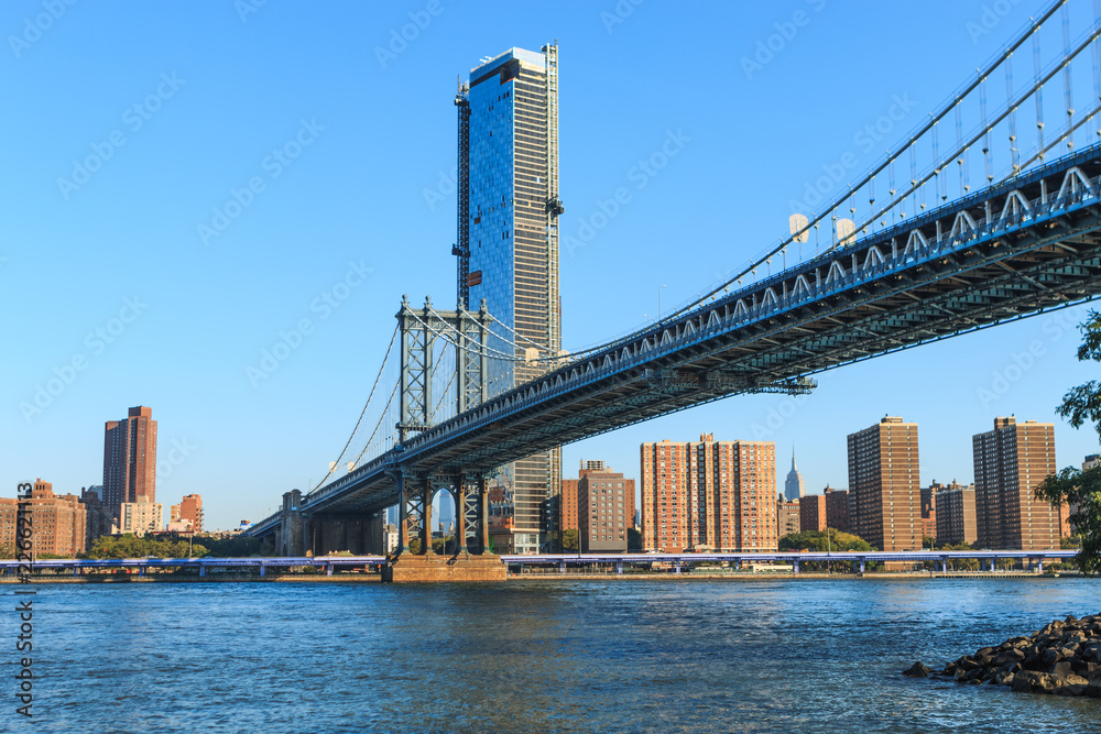 Manhattan Bridge over East River at the early morning sun light. The Bridge connects Lower Manhattan with Brooklyn of New York, USA. Manhattan Bridge over East River at the early morning sun light. The Bridge connects Lower Manhattan with Brooklyn of New York, USA.