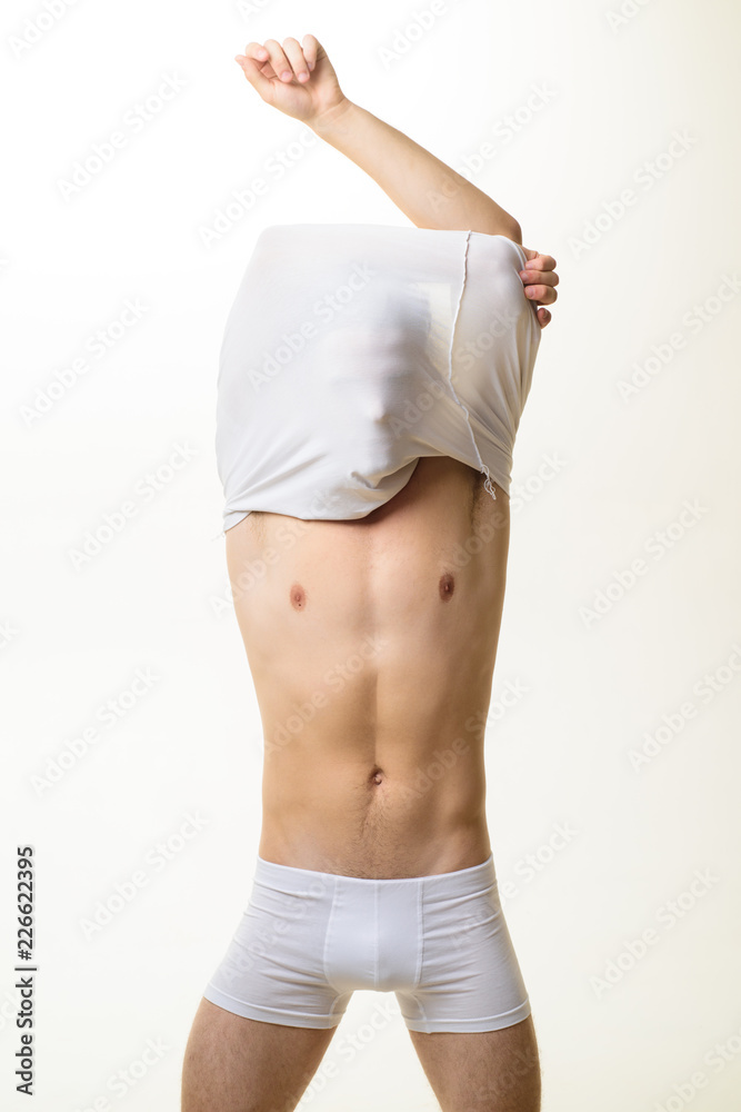 Handsome man taking off white t-shirt. Underwear. Sexy guy in underwear.  Black Friday. Man in boxer shorts. Male model showing bare torso. Fitness  model. Handsome man. Man underwear. Isolated. Photos | Adobe