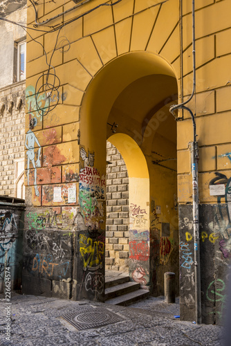 Graffiti on yellow archway in colourful streets of Naples Italy © Snapvision