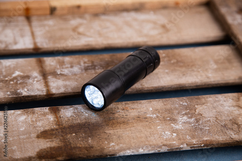 LED flashlight, on wooden background