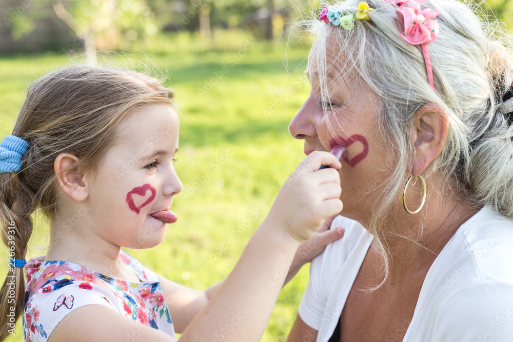 Cute girl making up her grandmother