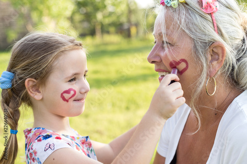 Cute girl making up her grandmother