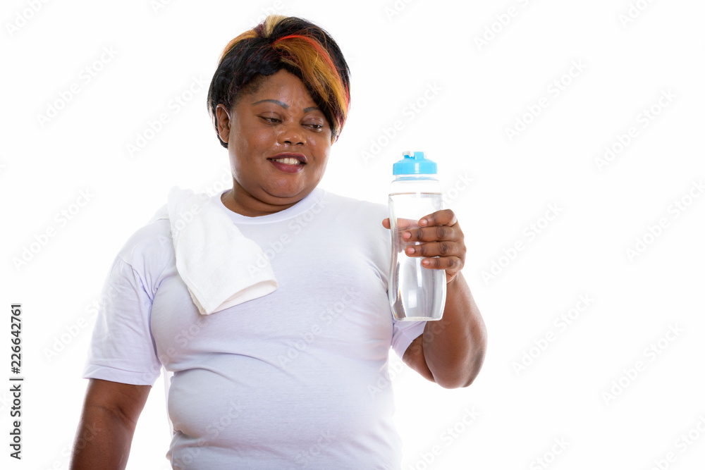 Studio shot of happy fat black African woman smiling while holdi Studio shot of happy fat black African woman smiling while holdi