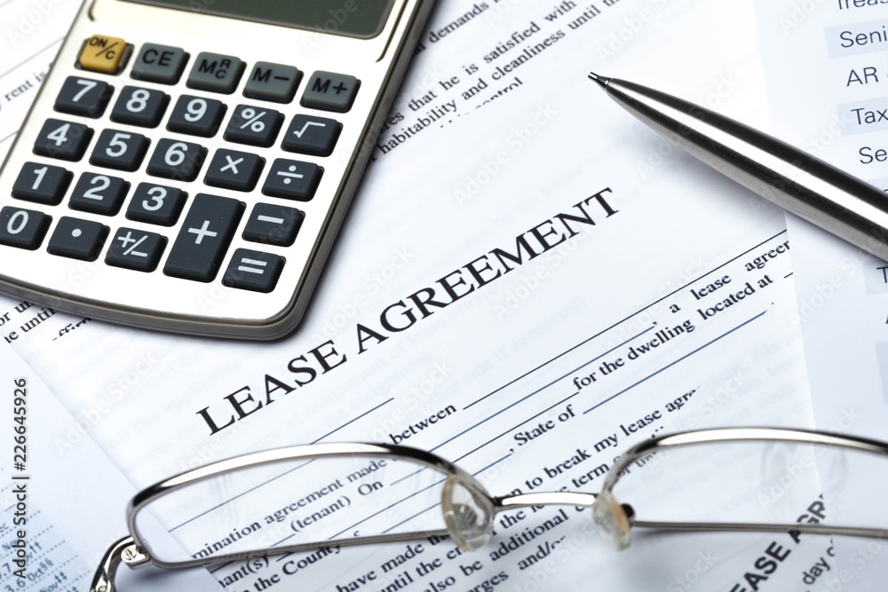 Lease Agreement Documents with Glasses, Pen and Calculator Lease Agreement Documents with Glasses, Pen and Calculator