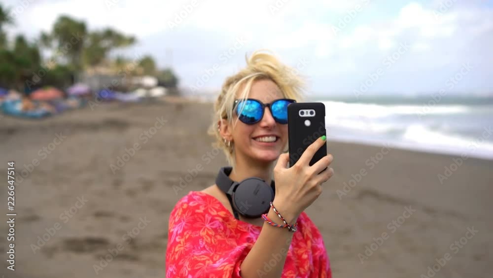 Young happy woman chatting on smartphone on the beach Young happy woman chatting on smartphone on the beach