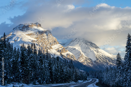 Driving Through Snow Covered Mountains Peaks in Evening