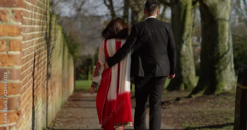 4K Happy romantic South Asian couple walking together along quiet country street. Slow motion. 4K Happy romantic South Asian couple walking together along quiet country street. Slow motion.