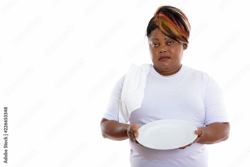Studio shot of fat black African woman holding empty white plate Studio shot of fat black African woman holding empty white plate