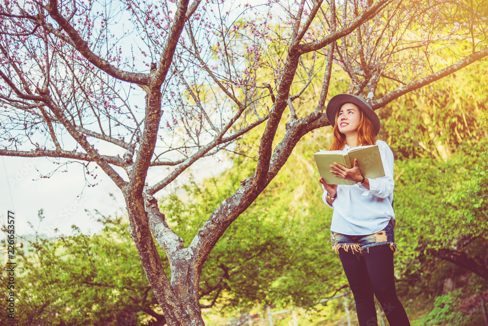 Asian woman travel nature. Travel relax. Reading book On the in the park. in summer. Asian woman travel nature. Travel relax. Reading book On the in the park. in summer.