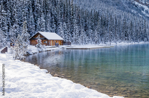 Log Cabin Alongside Mountain Lake in Winter