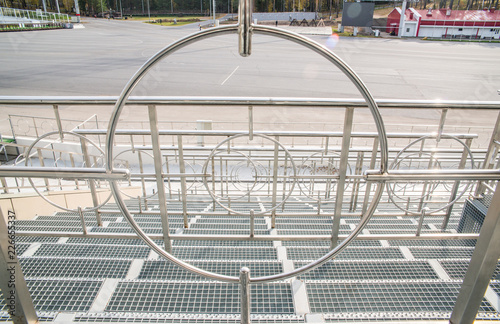 Matallic design of the stands and through the circle of the fence are seen traveling biathletes photo