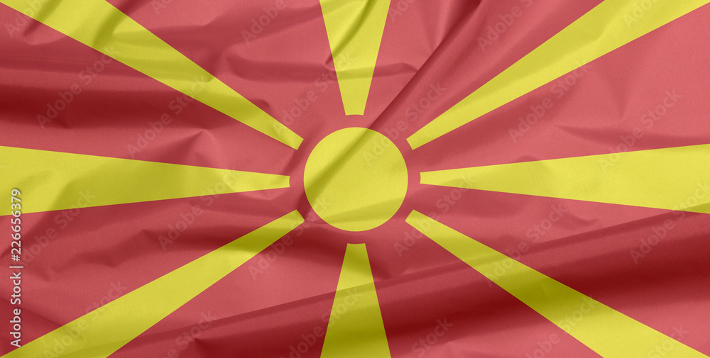 Fabric flag of Macedonia. Crease of Macedonian flag background, yellow sun  on a red field, with eight broadening rays extending from the centre to the  edge. Stock Photo | Adobe Stock