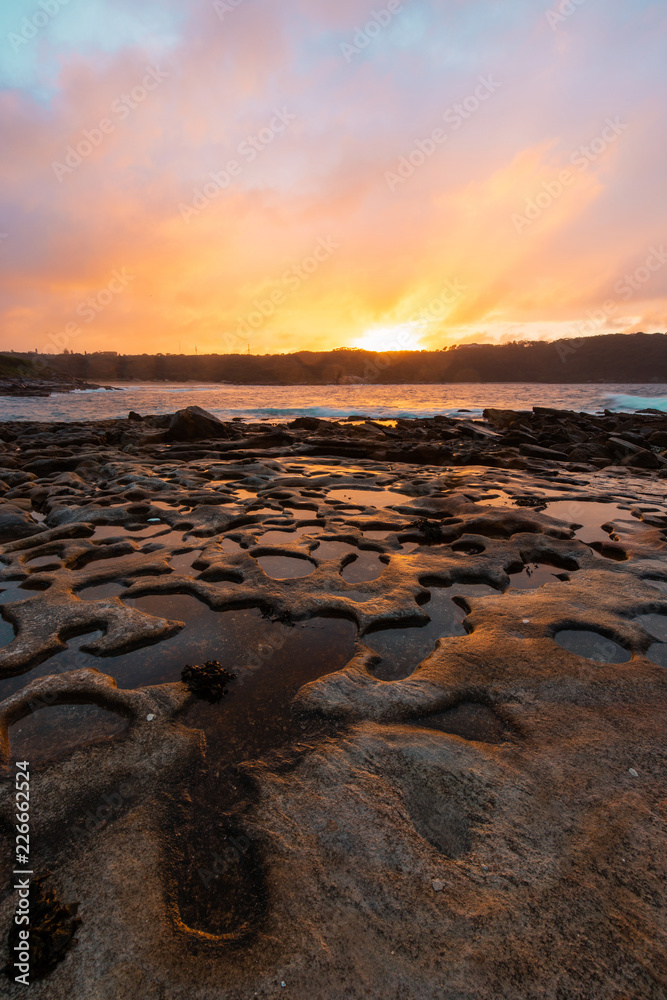 Obraz premium Warm sunrise light on the rocky coastline.