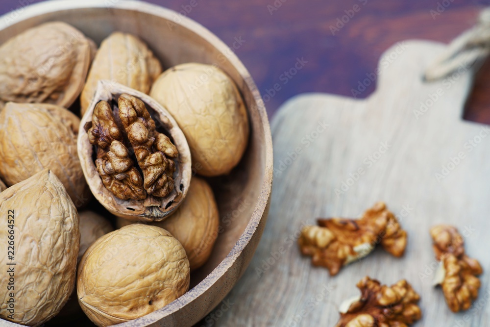 Group of walnut in wooden bowl on wood background, copy space, super food concept