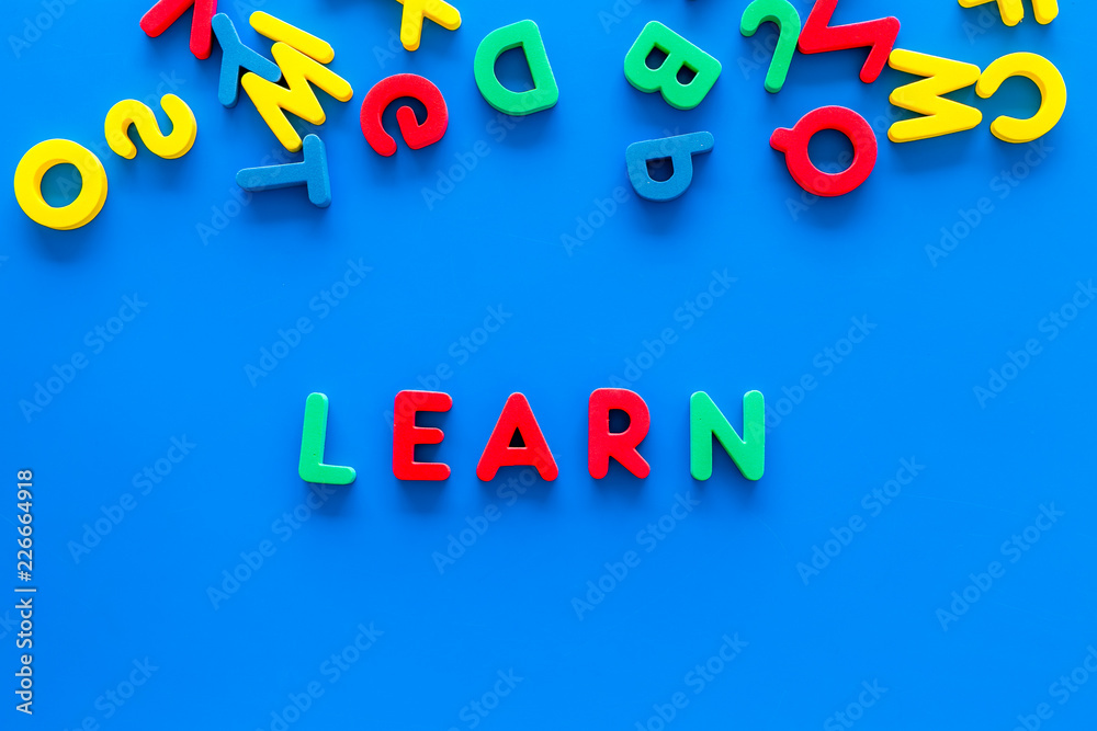 Fototapeta premium Children learn read concept. Word learn written by plastic letters on blue background top view copy space