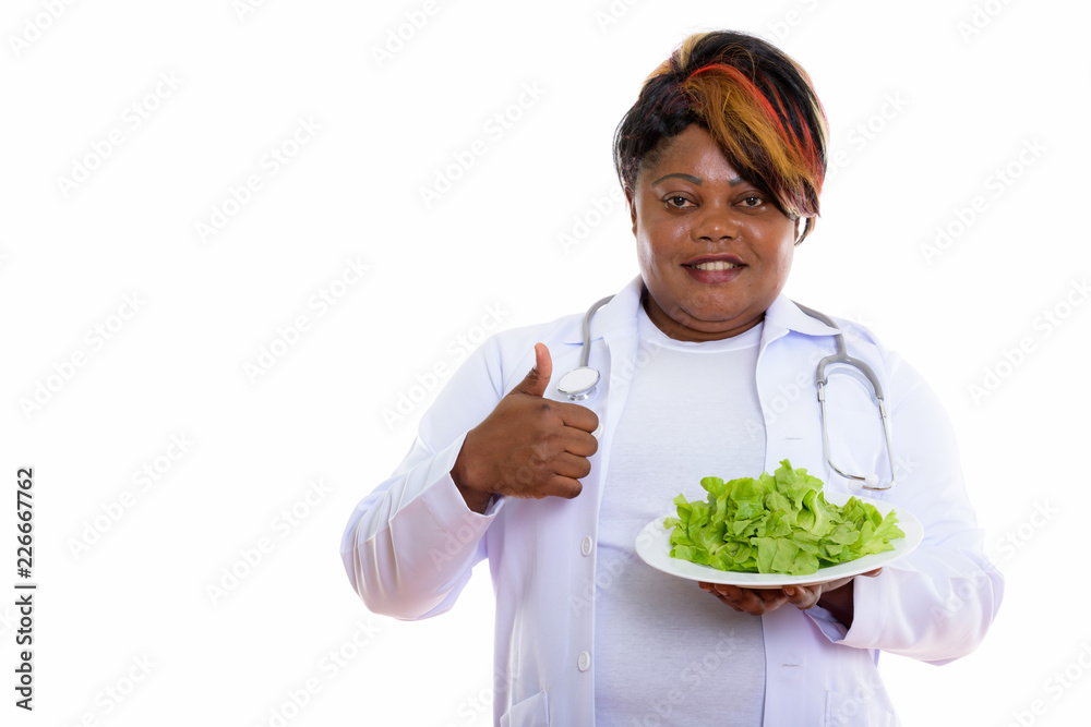Studio shot of happy fat black African woman doctor smiling and Studio shot of happy fat black African woman doctor smiling and