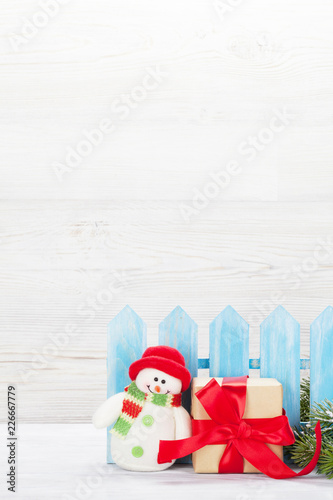 Christmas snowman toy, gift box and fir tree branch