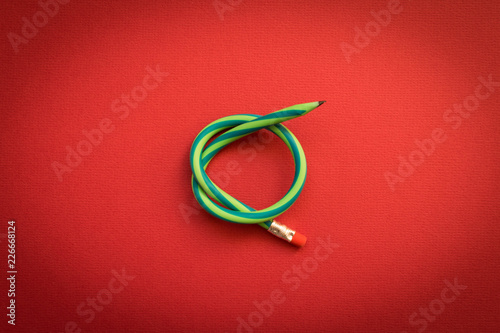 Flexible pencil . Isolated red background