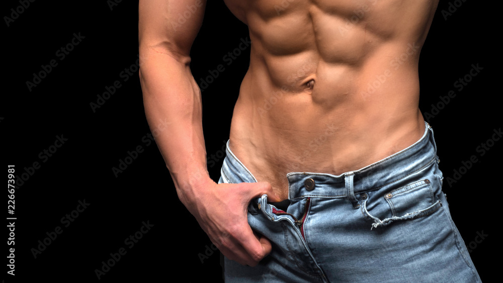 Closeup torso of shirtless muscular man posing on a black background Closeup torso of shirtless muscular man posing on a black background
