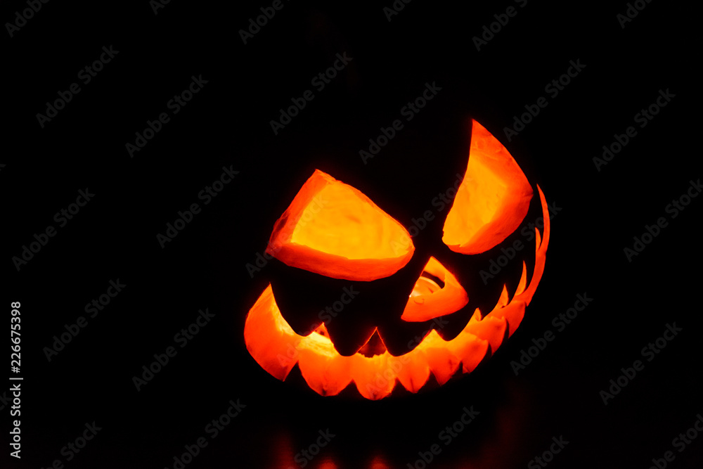 Fototapeta premium Spooky halloween pumpkin on a black background
