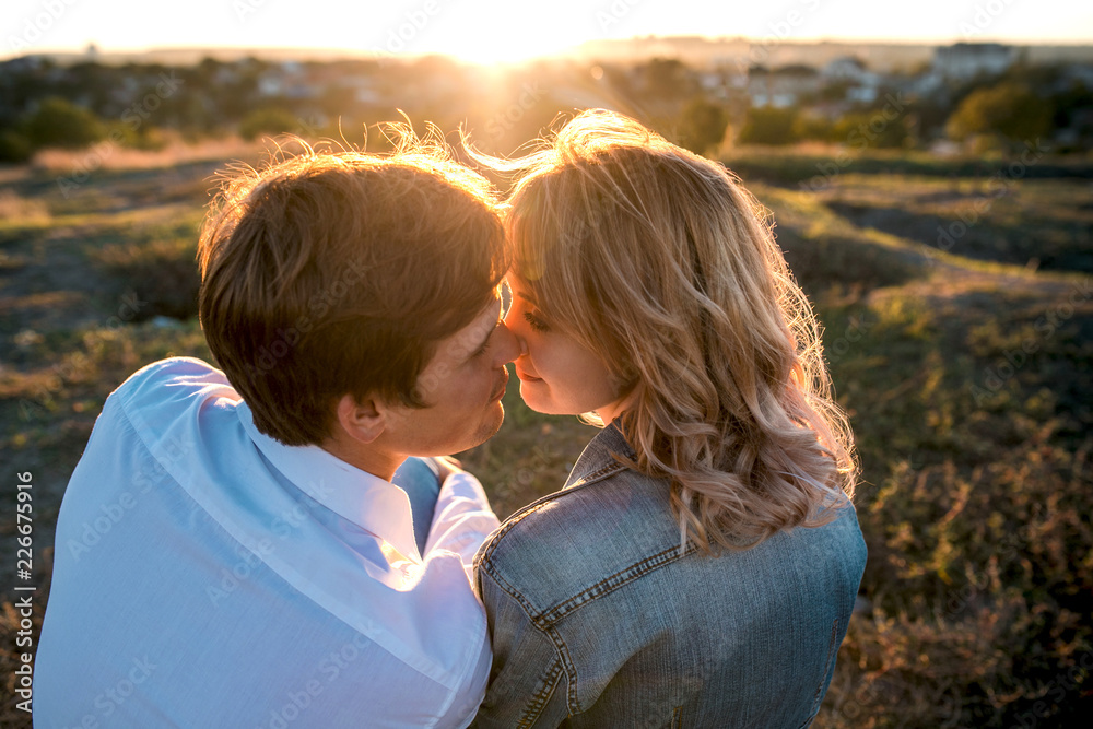 Loving couple is about kiss at sunset. Loving couple is about kiss at sunset.
