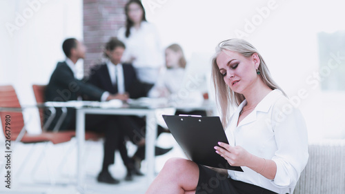 female assistant with the minutes of the meeting on the background of the office