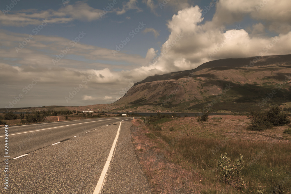 Beautiful icelandic deserted roadway along ocean fiord and green hills. Copy space.