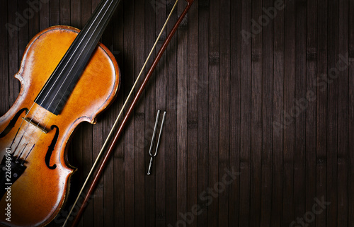 Quadro su tela violin bow and tuning forks on a dark wooden background