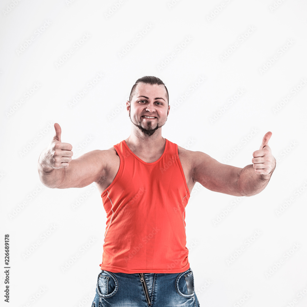 portrait of sporty guy - bodybuilder in jeans and an orange shir portrait of sporty guy - bodybuilder in jeans and an orange shir