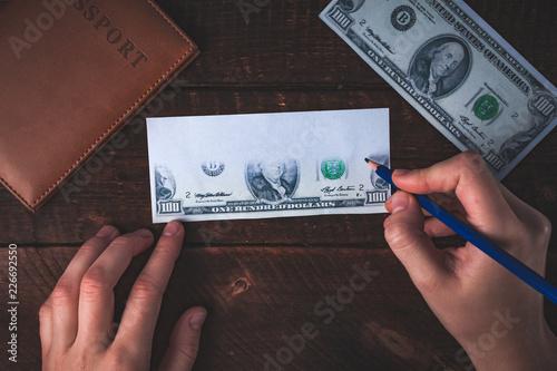 Counterfeiter forges banknotes. Fake concept. Fake money, American 100 dollars, a passport on a wooden background photo