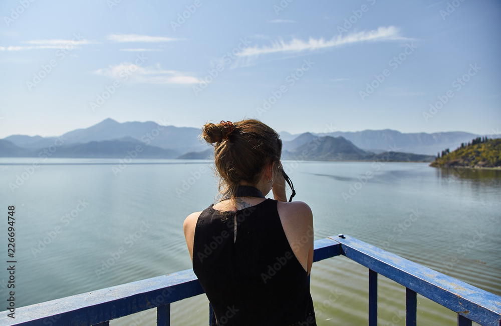 A young Girl photographs the lake. Tourist takes a photo of Skadar lake. Skadar lake. National park. Montenegro. 