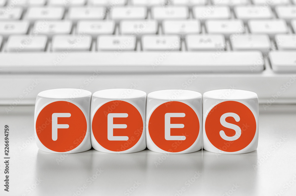 Letter dice in front of a keyboard - Fees Letter dice in front of a keyboard - Fees