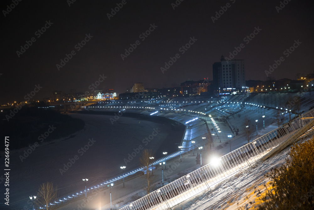Night view of the embankment of the river Tura. Tyumen city. Russia