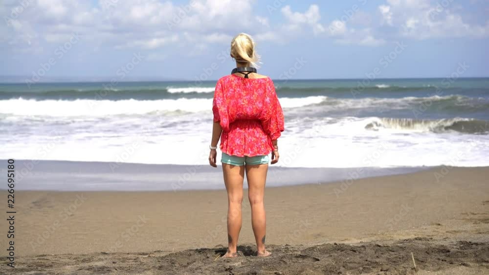 Woman enjoying, admire sea waves on the beach Woman enjoying, admire sea waves on the beach