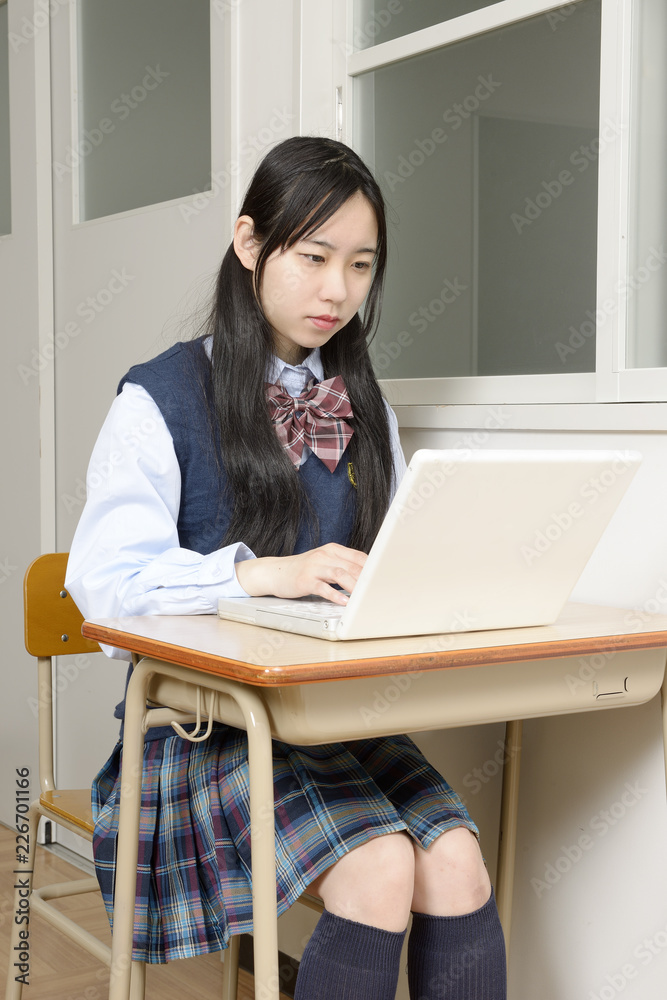 真剣にパソコンで勉強する女子高校生 真剣にパソコンで勉強する女子高校生