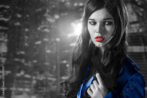 woman in a blue coat with red lips black and white in the city of sins