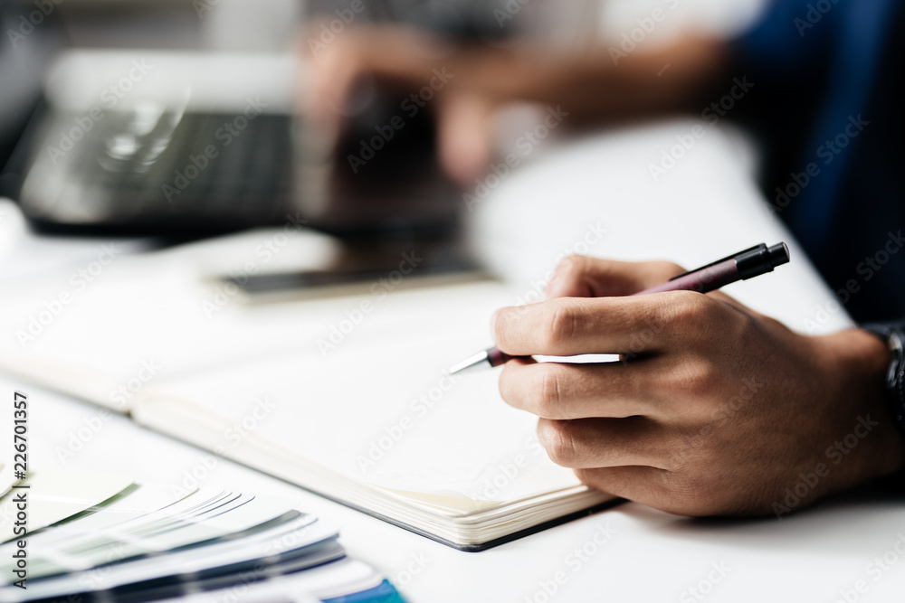 Man makes notes in a notebook on a table Man makes notes in a notebook on a table
