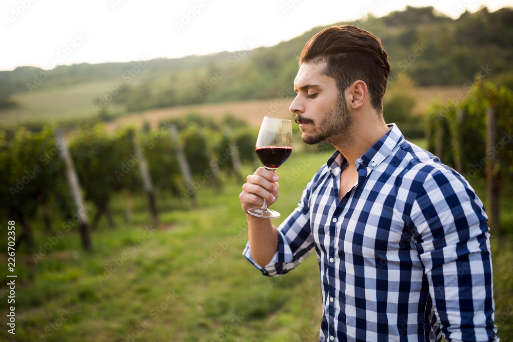 Fototapeta premium Wine growers tasting wine in vineyard