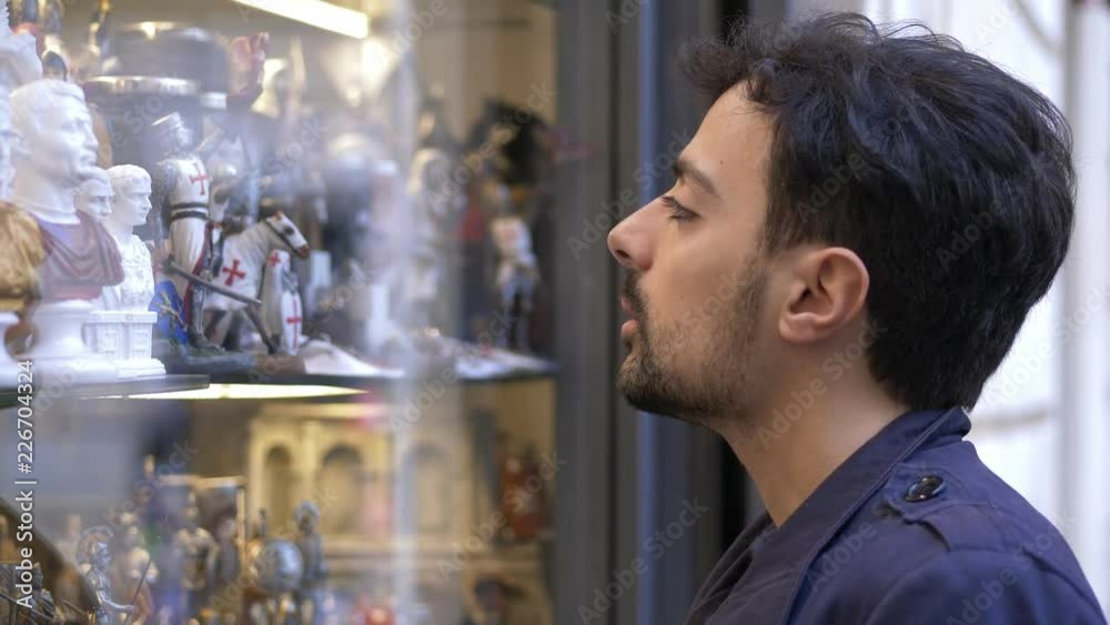 young man looks at a shop window in the street young man looks at a shop window in the street