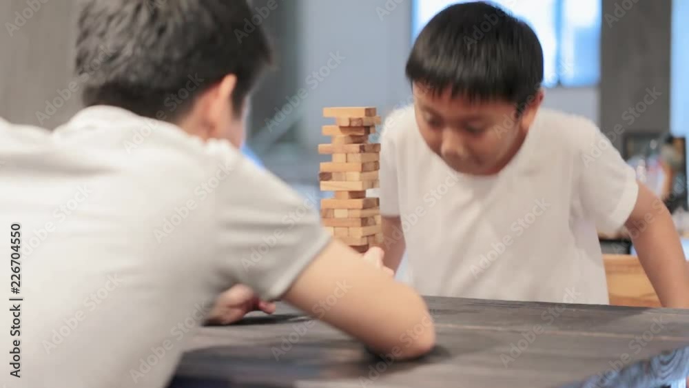 Happy asian family and cute little boy thinking playing a round of wooden block game at home Happy asian family and cute little boy thinking playing a round of wooden block game at home