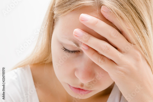 Young, adult blonde lady trying to calm down. Lonely, grieving, nervous woman touching head. Memory disorder. Suffering from burnout or other psychological problems. Women's issues. Face close up.