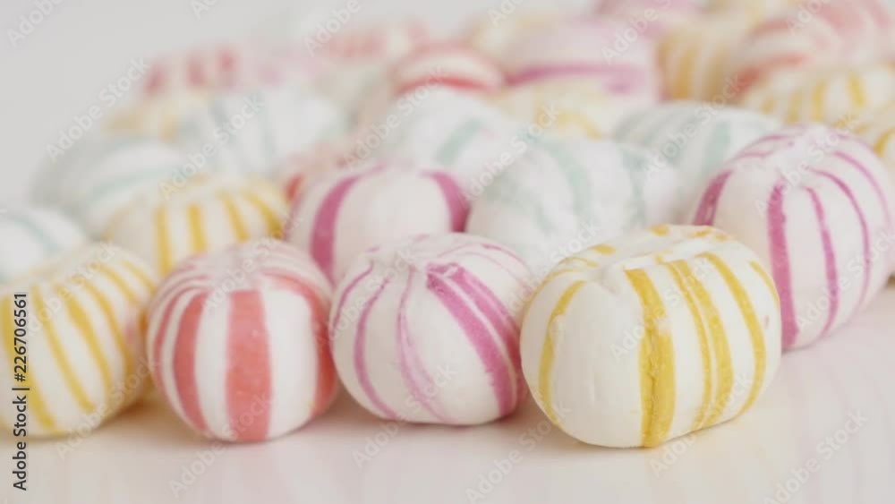 Lot of striped sugar bonbons on white close-up 4K video Lot of striped sugar bonbons on white close-up 4K video